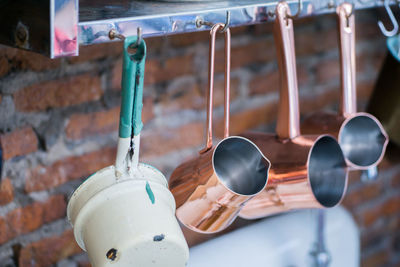 Close-up of kitchen utensils hanging from rack in kitchen