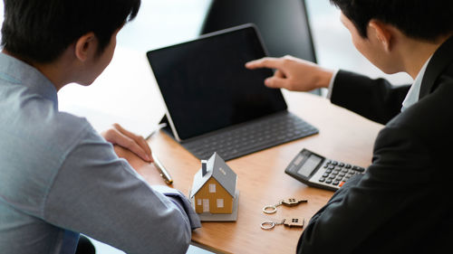 Midsection of man using laptop on table