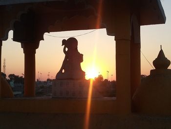 Silhouette of statue at sunset