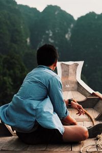 Rear view of man sitting outdoors