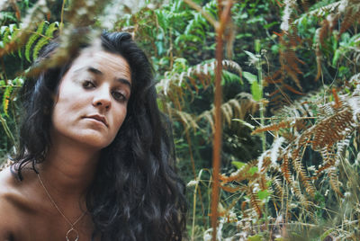 Close-up portrait of shirtless woman in forest