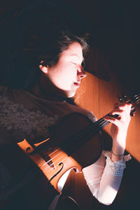 Woman with eyes closed holding violin