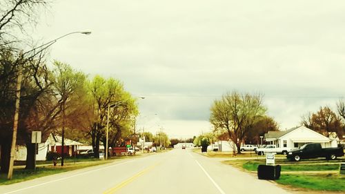 Road amidst trees against sky