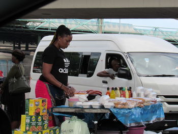 Side view of woman standing in car