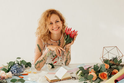 Portrait of a smiling young woman against white wall