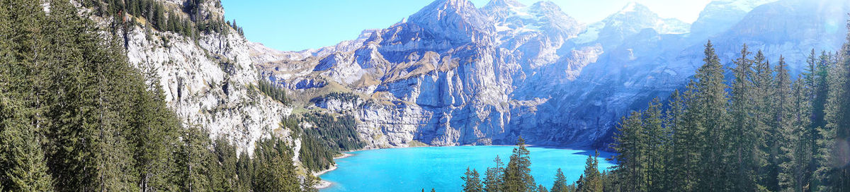 Panoramic view of land and mountains against blue sky