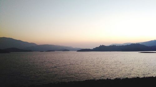 Scenic view of lake and mountains against clear sky