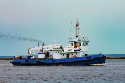 Ship moored on sea against clear sky