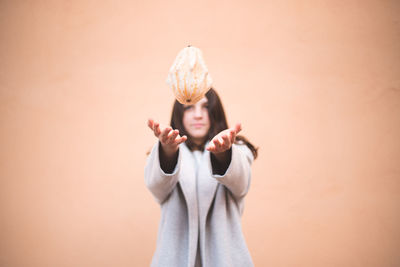 Portrait of man holding camera against wall