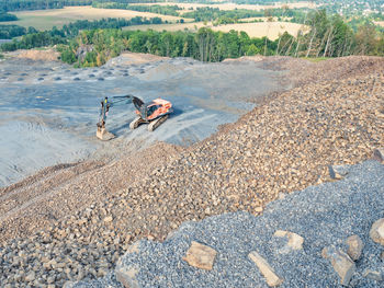 Belt conveyor loader wait for dump truck. heavy machinery in clinkstone or phonolite mining quarry