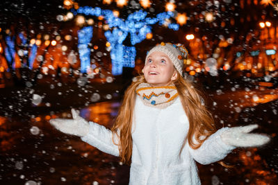 Portrait of girl standing on snow during christmas