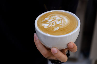 Close-up of hand holding coffee cup