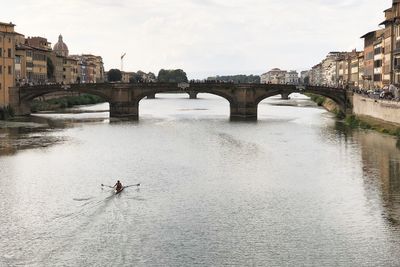 Arch bridge over river against sky