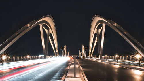 Light trails on bridge in city at night