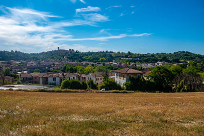 Little ancient town of colle val d'elsa, tuscany, behind a field and against blue sky