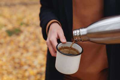 Midsection of man pouring coffee in cup