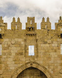 Low angle view of historical building against cloudy sky