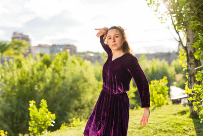 Portrait of young woman standing on field