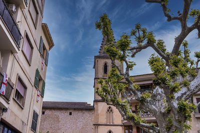 Low angle view of church of sant bartomeu de soller against blue sky in town