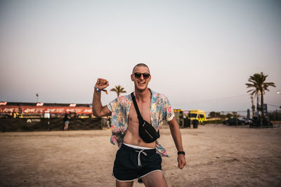 Portrait of man wearing sunglasses standing on beach