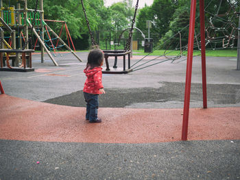 Rear view of baby girl standing at playground