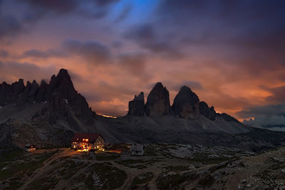 Scenic view of mountains against cloudy sky during sunset