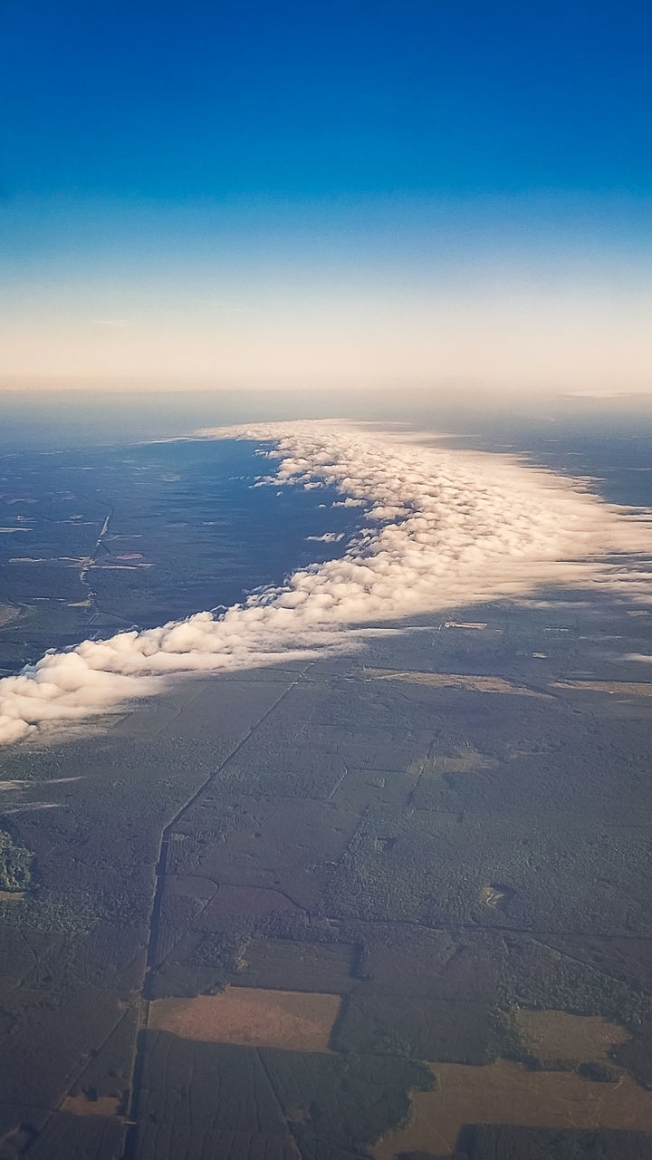 horizon, sky, aerial view, environment, scenics - nature, landscape, nature, dawn, beauty in nature, land, blue, cloud, reflection, tranquility, aerial photography, travel, no people, water, sunlight, outdoors, tranquil scene, plain, sunrise, airplane, air vehicle, high angle view, transportation, day, sea, idyllic, travel destinations, cold temperature, cloudscape, flying, urban skyline, winter, beach, tourism