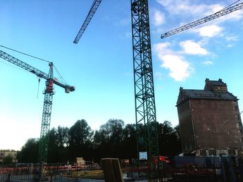 Low angle view of cranes against sky