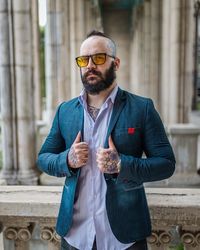 Young man wearing hat standing against wall