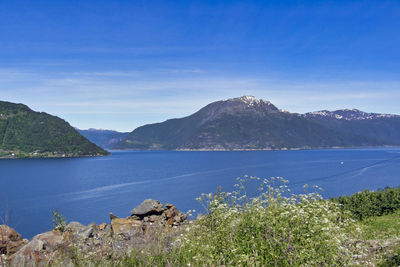 Scenic view of sea and mountains against sky