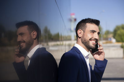 Young businessman using cell phone near the office