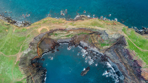 High angle view of rocks on sea shore