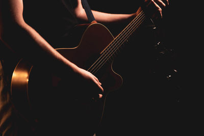 Midsection of man playing guitar