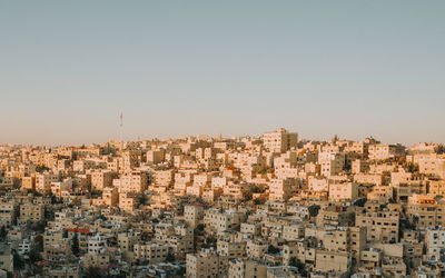 Aerial view of buildings in city against clear sky