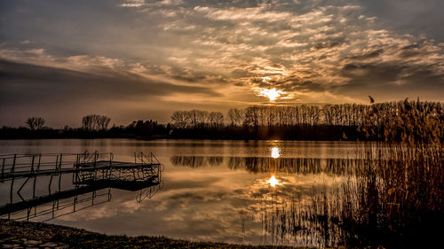 Scenic view of lake against sky at sunset