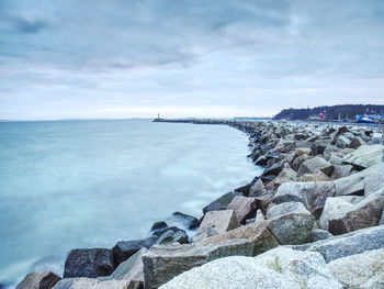 Lighthouse tower on stony concrete mole in sasssnitz town port, ruegen island, germany. lighthouse