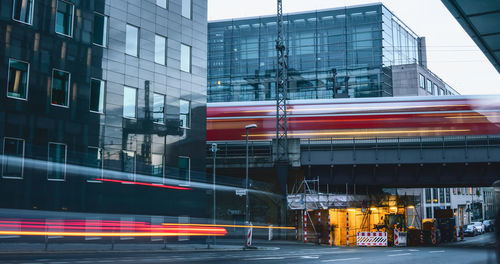 Blurred motion of train against buildings in city