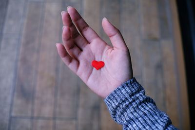 Cropped hand holding heart shape decoration