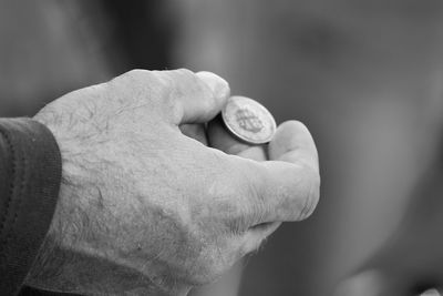 Close-up of man holding coin