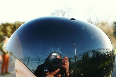 Reflection of woman photographing on helmet