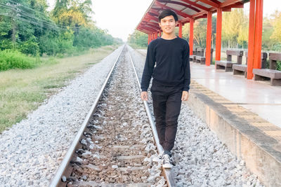 Portrait of man standing on railroad track