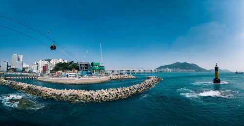 View of buildings by sea against sky