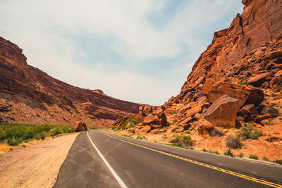 Road leading towards mountains against sky