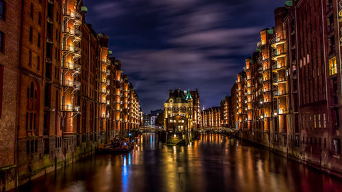 View of illuminated bridge over river at night