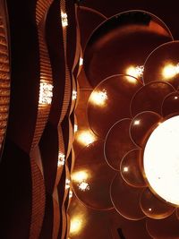 Low angle view of illuminated lighting equipment hanging on ceiling
