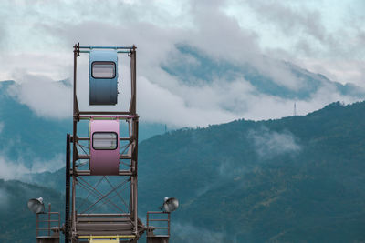 Ferris wheel against foggy mountains