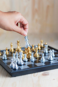 Cropped hand playing chess on table