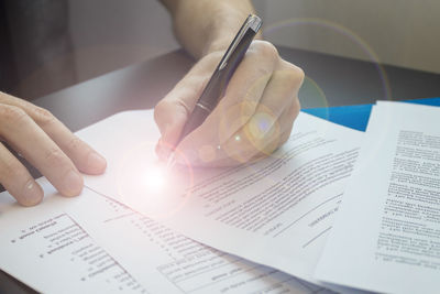 Close-up of hand holding book on table