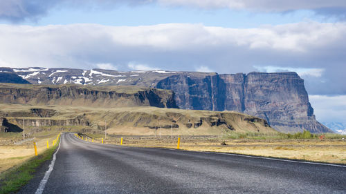 Road by mountain against sky