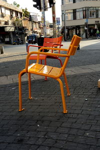 Empty sidewalk cafe by street in city